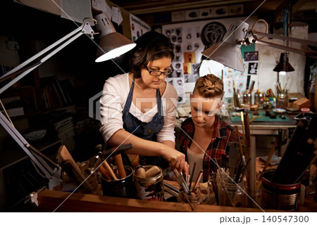 Women, craft and tools in workbench for creative design, wood sculpture or handmade project at night. Artist, collaboration and manufacturing in studio with teamwork, assistance and workshop skills Women, craft and tools in workbench for creative design, wood sculpture or handmade project at night. Artist, collaboration and manufacturing in studio with teamwork, assistance and workshop skills 140547300