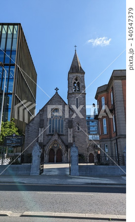 Dublin, Ireland - May 28, 2023: Historic church building surrounded by modern development in Dublin. 140547379