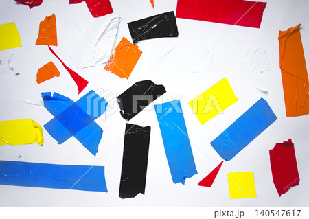 Colorful pieces of torn adhesive tape in various shapes and sizes scattered on a white background, showcasing vibrant hues of red, blue, yellow, black, and orange Colorful pieces of torn adhesive tape in various shapes and sizes scattered on a white background, showcasing vibrant hues of red, blue, yellow, black, and orange 140547617