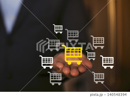Businessman holding hand with digital shopping cart icons, one highlighted in yellow, representing e-commerce and online shopping concepts in a modern setting Businessman holding hand with digital shopping cart icons, one highlighted in yellow, representing e-commerce and online shopping concepts in a modern setting 140548394