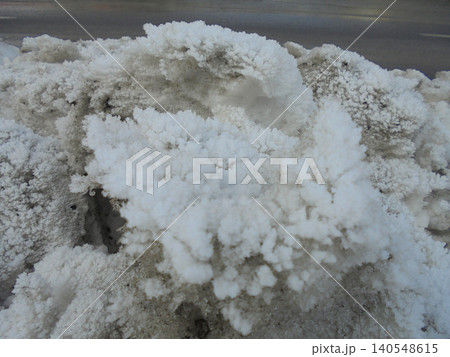 Mounded snow boulders covered by dense white frost next to the road. 140548615