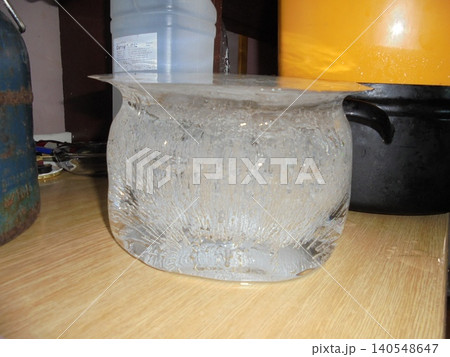 Bucket-shaped ice with crystallic structures inside standing on a kitchen unit Bucket-shaped ice with crystallic structures inside standing on a kitchen unit 140548647