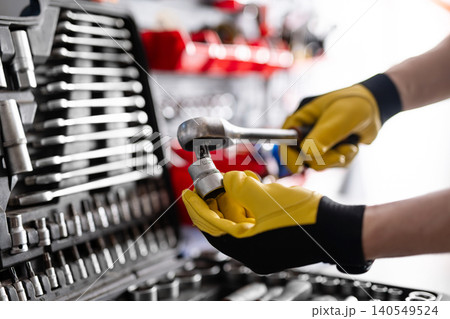Auto Mechanic With Ratchet Wrench With Socket Tool 140549524