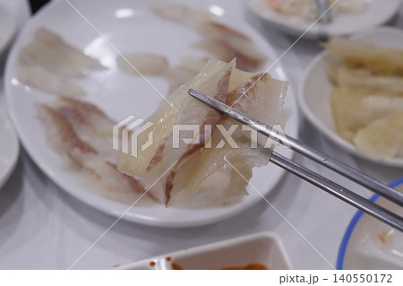 Chopsticks Holding Delicate Seafood Slices 140550172