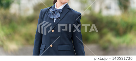 学校の校舎の前に立つ制服姿の中学生・高校生・小学生の女の子 140551720