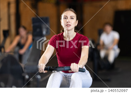 Woman exercising on a rowing machine Woman exercising on a rowing machine 140552097