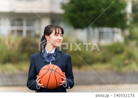 バスケットボールを持って校庭に立つ制服姿の高校生,中学生,小学生の女の子 140552178