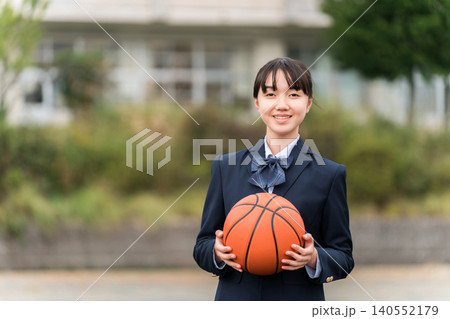 バスケットボールを持って校庭に立つ制服姿の高校生,中学生,小学生の女の子 140552179