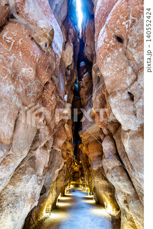 Illuminated narrow passage inside the ancient Al Qarah Mountain caves in Al Ahsa, Saudi Arabia, a popular natural tourist attraction. Illuminated narrow passage inside the ancient Al Qarah Mountain caves in Al Ahsa, Saudi Arabia, a popular natural tourist attraction. 140552424