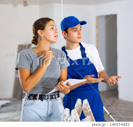 Young worker discusses project documentation of desing with a girl client 140554883
