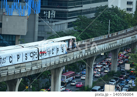 A Silom Line BTS Skytrain traveling along its elevated track bed high above busy Ratchadamri Road in Bangkok, Thailand. A Silom Line BTS Skytrain traveling along its elevated track bed high above busy Ratchadamri Road in Bangkok, Thailand. 140556004