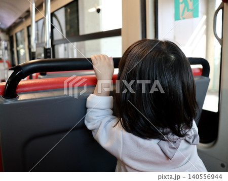 バス車内の最後部座席に座り景色を見る女の子の幼児の後ろ姿｜Web・出版・子育て・公共交通・地域PR 140556944
