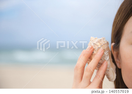 A woman listening to the sound of the sea in Sora A woman listening to the sound of the sea in Sora 140557019