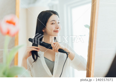 ストレートヘアアイロンを使う女性 ストレートヘアアイロンを使う女性 140557071