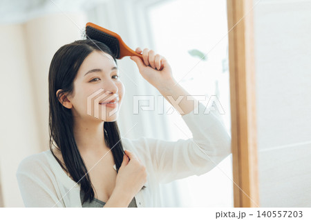 ヘアブラシを使う若い女性 ヘアブラシを使う若い女性 140557203