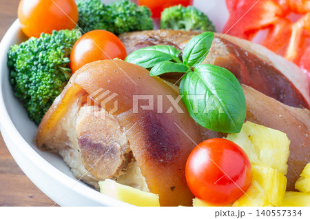 Baked HAM steaks lie on green lettuce leaves, cherry tomatoes and broccoli. Baked HAM steaks lie on green lettuce leaves, cherry tomatoes and broccoli. 140557334