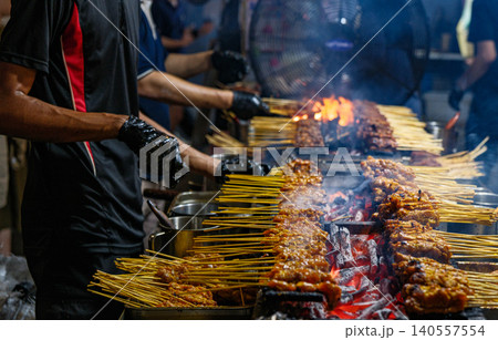 Fresh Chicken and Beef Satay Skewers Being Grilled Over Open Charcoal Flames at a Famous Singapore Hawker Centre Street Stall 140557554