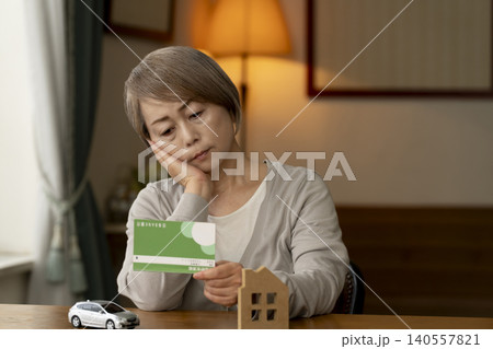 金利の上昇で老後資金に不安なシニア女性 140557821