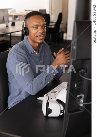 African american male office worker gesturing at screen in meeting with vr headset African american male office worker gesturing at screen in meeting with vr headset 140558942