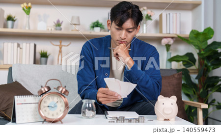 Asian man in his 20s or 30s planning personal finance and budget at home 140559473