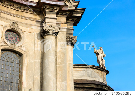 Detailed view of a historic European cathedral's exterior architecture, featuring ornate columns, stained glass windows, and a prominent religious sculpture Detailed view of a historic European cathedral's exterior architecture, featuring ornate columns, stained glass windows, and a prominent religious sculpture 140560296