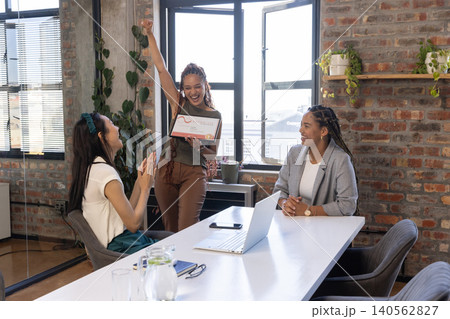 Diverse female coworkers clapping and celebrating holding framed certificate in office meeting room 140562827
