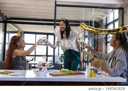 Diverse female colleagues gathering at conference table, cupcake stand, charcuterie and gold decor 140562829
