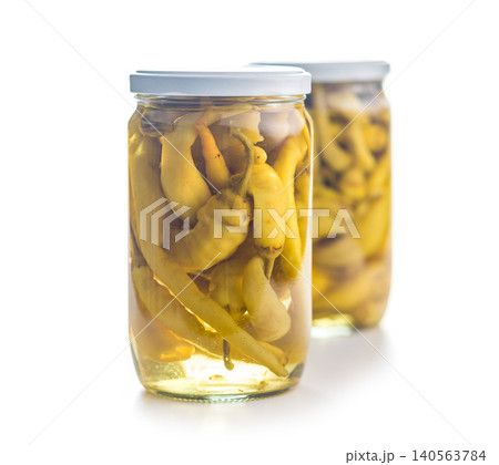 Two Glass Jars of Pickled Yellow Peppers in Brine on White Background Two Glass Jars of Pickled Yellow Peppers in Brine on White Background 140563784