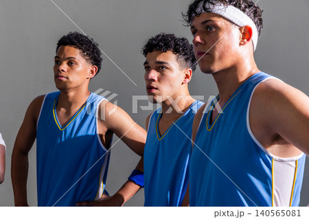 African american teenage male basketball team posing in gym wearing blue jerseys, headband African american teenage male basketball team posing in gym wearing blue jerseys, headband 140565081