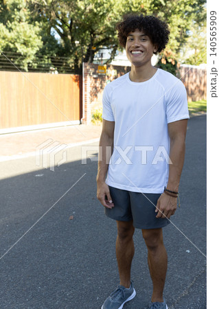 African american man standing on street in bright sunlight, wearing athletic African american man standing on street in bright sunlight, wearing athletic 140565909