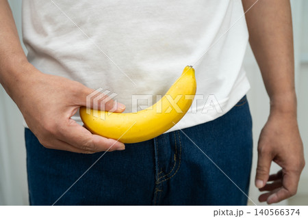 Male stands holding a banana, penis health. Male stands holding a banana, penis health. 140566374