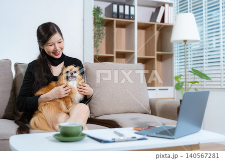 Happy woman sitting on a sofa with dog her, relaxed lifestyle at home. Happy woman sitting on a sofa with dog her, relaxed lifestyle at home. 140567281