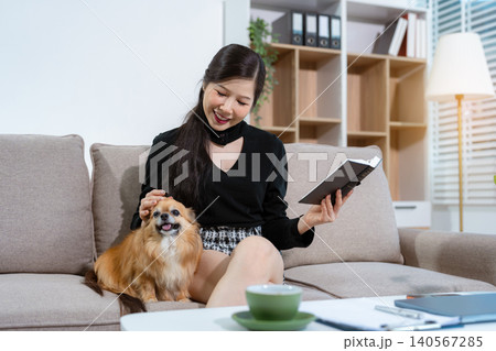Cozy woman reading on a sofa with dog her, relaxed lifestyle at home. Cozy woman reading on a sofa with dog her, relaxed lifestyle at home. 140567285