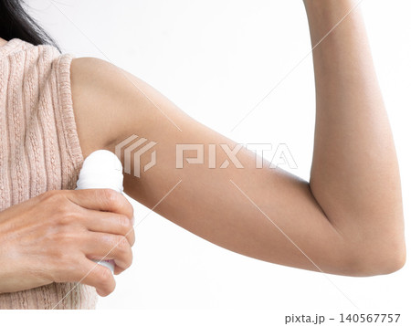 Woman applying deodorant roll on ynder armpit after shower, dirl using deodorant body in bathroom at home before antiperspirant, authentic skin tan. Woman applying deodorant roll on ynder armpit after shower, dirl using deodorant body in bathroom at home before antiperspirant, authentic skin tan. 140567757