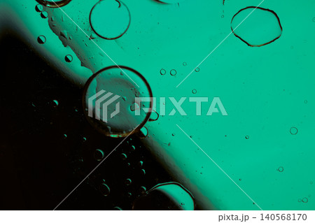 Macro shot of fluid dynamics showing floating oil drops over vibrant, colorful light leaks Macro shot of fluid dynamics showing floating oil drops over vibrant, colorful light leaks 140568170