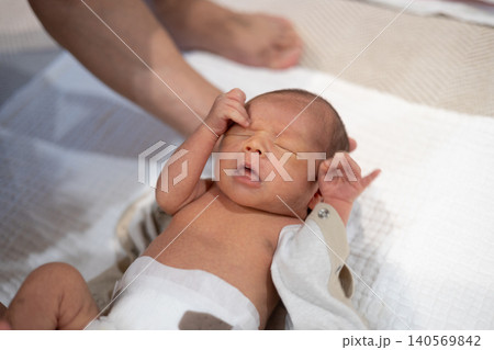 パパに着替えさせてもらっている生後10日の新生児 パパに着替えさせてもらっている生後10日の新生児 140569842