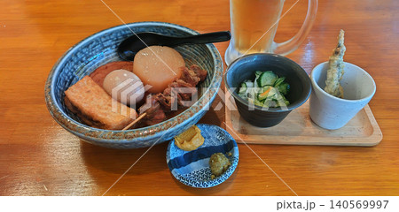 鳥取県のご当地グルメ 牛骨スープの「牛骨おでん」に小鉢と天ぷら、冷えたビールを添えた居酒屋の晩酌御膳 140569997