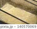 高温の油で揚げられるフライドポテトのクローズアップ 140570069