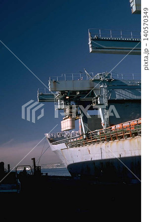 A Large Cargo Ship with Drums Loading Cranes at Port 140570349
