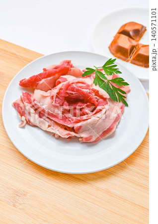 白い皿に盛り付けられた生の牛バラ薄切り肉とルー 白い皿に盛り付けられた生の牛バラ薄切り肉とルー 140571101