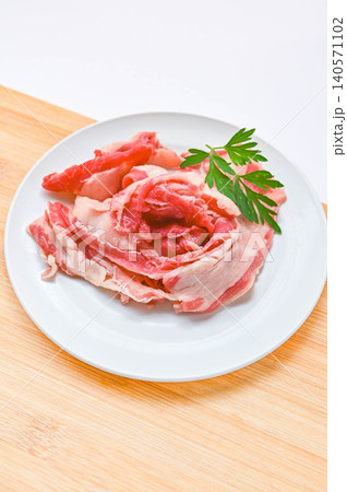 白い皿に盛り付けられた生の牛バラ薄切り肉 140571102