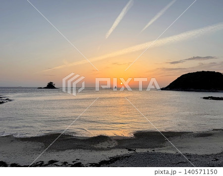 夕日が沈む海岸と穏やかな海の風景 140571150