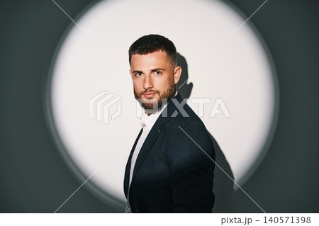 Elegant businessman in black suit under spotlight Elegant businessman in black suit under spotlight 140571398