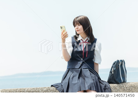 スマホを持つ女子高生 140571450