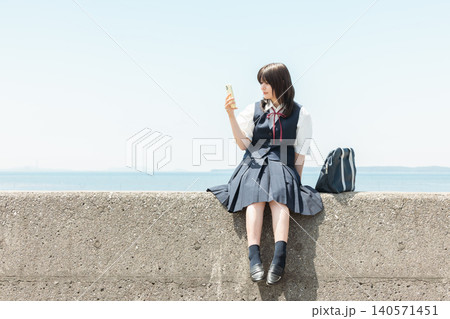 海でスマホを使う女子高生 海でスマホを使う女子高生 140571451