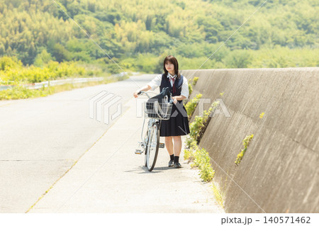 田舎道を自転車を押して歩く制服姿の女子高校生 田舎道を自転車を押して歩く制服姿の女子高校生 140571462