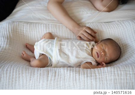 寝ている赤ちゃん(新生児)とあやしているお母さんの手 寝ている赤ちゃん(新生児)とあやしているお母さんの手 140571616