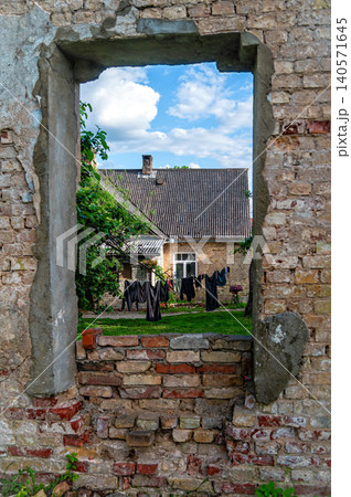 Old house with open window showing laundry outside in backyard 140571645
