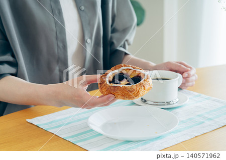 ダークチェリーのデニッシュを食べる若い女性 ダークチェリーのデニッシュを食べる若い女性 140571962