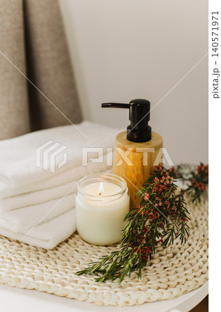 Minimalist still life of luxury spa essentials. White cotton towels with visible textured, bottle with oil and soy wax candle. 140571971